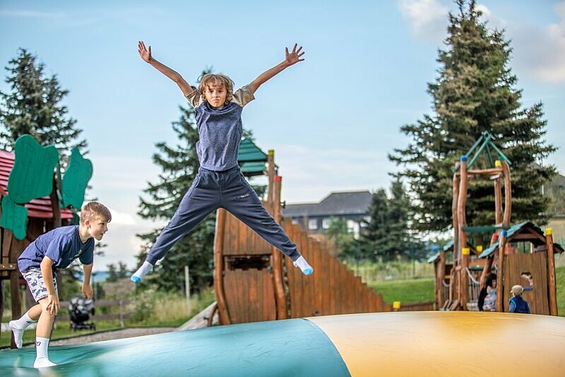 Ein Junge springt begeistert auf dem Riesenjumpkissen.