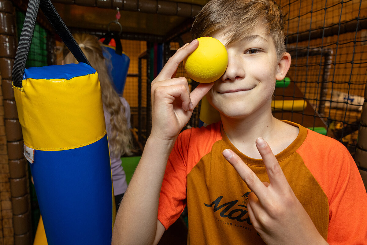 Ein Teenager fordert zur Softball-Challenge im Indoorspielplatz auf!